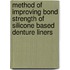 Method of improving bond strength of silicone based denture liners